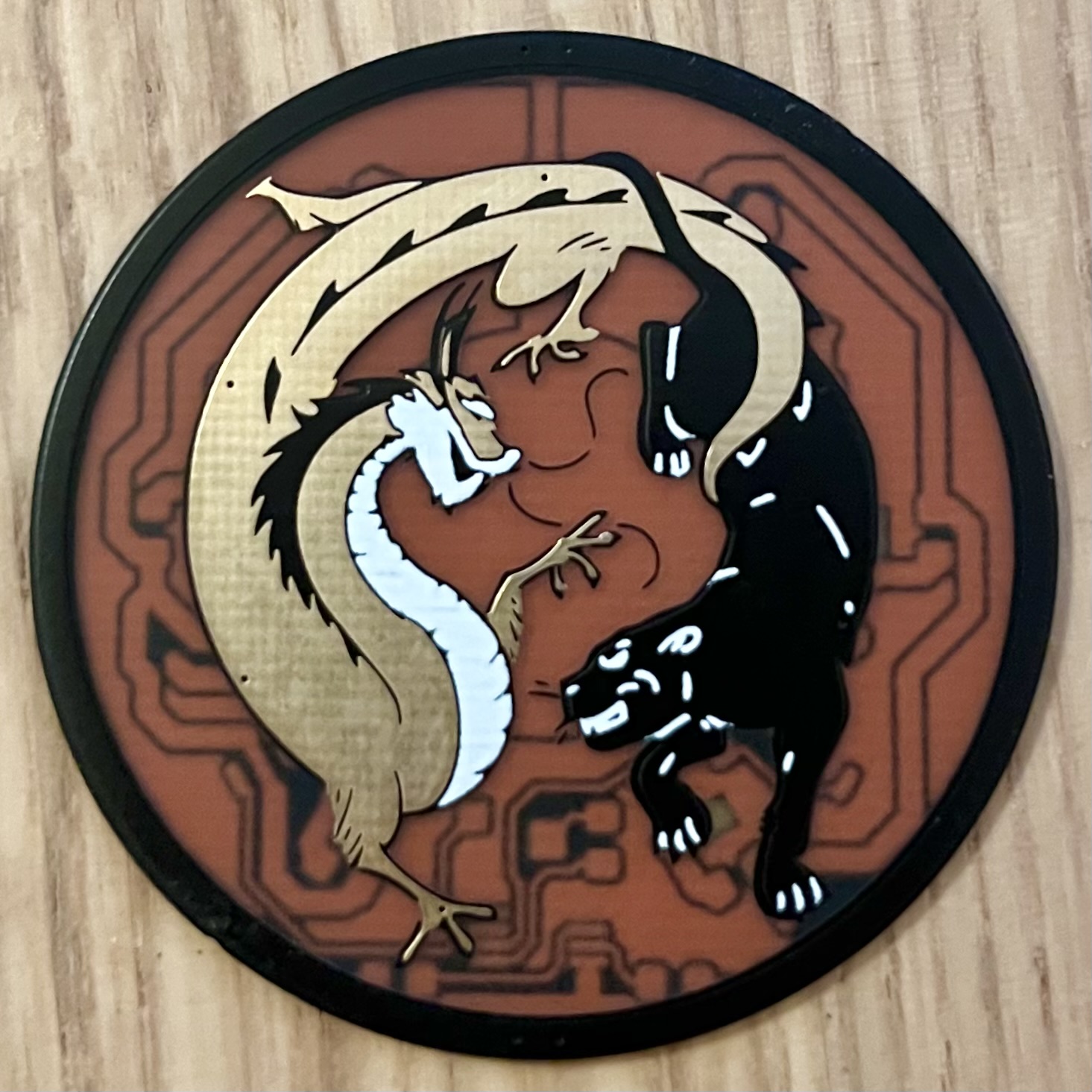 Dragon/Panther circular PCB badge — a white dragon and black panther intertwined over copper traces
